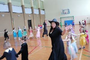 Dzieci tańczą na sali gimnastycznej.