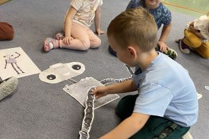 Maluchy układają robota Necia.