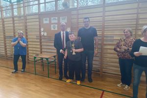 Wójt i opiekun z uczniem klasy czwartej trzymającym puchar i medal za III miejsce.