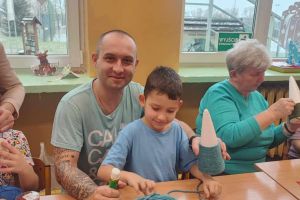 Rodzice pomagają ozdabiać choinkę