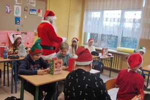 Święty Mikołaj rozdaje uczniom upominki.