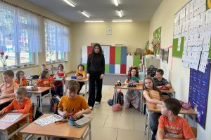 Uczennica klasy ósmej prowadzi lekcje w klasie pierwszej.