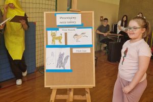 Uczennica klasy drugiej ze swoimi rysunkami podczas Pokazu Talentów.