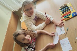 Dzieci wykonują pocztówki świąteczne.