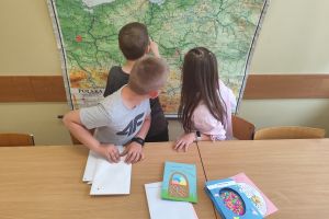 Uczniowie szukają na mapie Polski, gdzie znajdują się szkoły, z którymi nawiązali listowny kontakt.