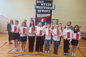 Wspólne zdjęcie uczniów klasy szóstej z wychowawcą i panią dyrektor po akademii.