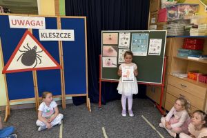 Dzieci zawieszają informacje o kleszczach na tablicy