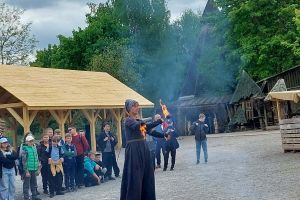 Uczniowie obserwują sztuczki wykonywane przez panią z ogniem.