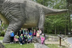 Wspólne zdjęcie uczestników wycieczki przy dinozaurze.
