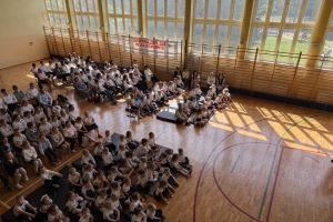 Uczniowie i dzieci oglądają akademie z okazji Dnia Patrona