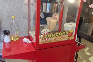 Pani przygotowuje popcorn dla dzieci.