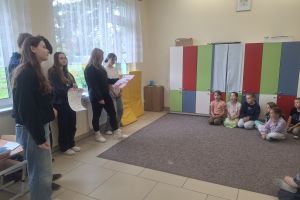 Uczniowie klasy ósmej prezentują uczniom klasy pierwszej plakaty dotyczące udzielania pierwszej pomocy.