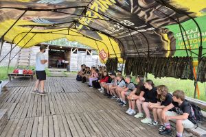 Uczniowie słuchają instruktażu na temat gry  w paintball.