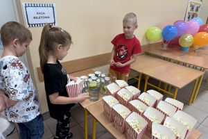 Dzieci kupują bilety na seans filmowy.