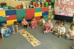 Dzieci wykonują zadania projektowe na dywanie.