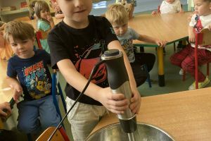 Dzieci wspólnie wykonują koktajl.