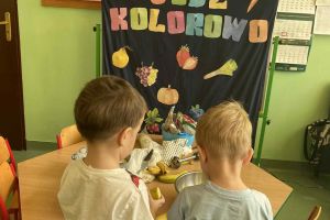 Dzieci dodają owoce do koktajlu.