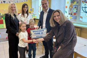 Przedszkolaki odbierają wygrany voucher.
