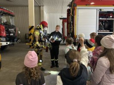 Strażacy zapoznają uczniów ze sprzętem bojowym.