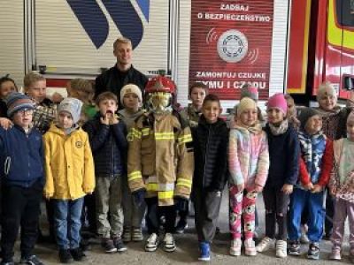 Dzieci na zdjęciu na tle wozu strażackiego.