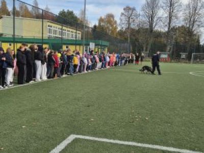 Uczniowie na boisku szkolnym czekają na pogadankę policjantów.
