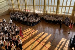 Społeczność szkolna śpiewa hymn.