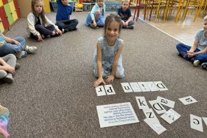 Dzieci układają wyraz z liter.