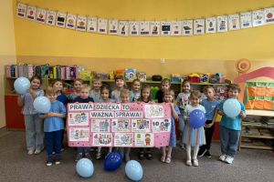 Dzieci prezentują się w wykonaną pracą plastyczną.