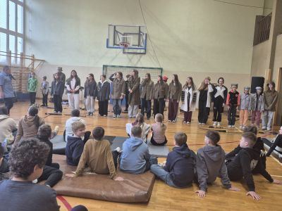 Uczniowie jako widownia oglądają omawiane mundury z różnych epok.