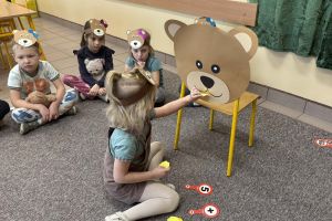 Dzieci przeliczają plasterki miodu i karmią misia.