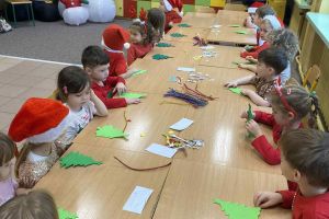 Dzieci wykonują choinkę na warsztatach.