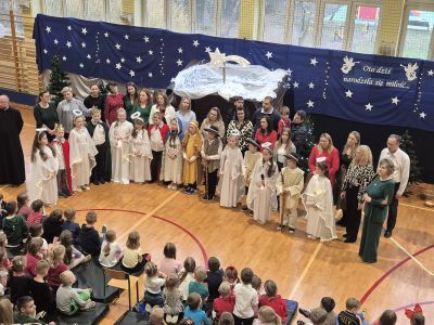 Uczniowie klasy trzeciej z rodzicami i nauczycielami śpiewają kolędę.
