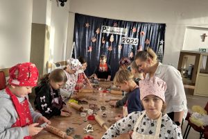 Uczniowie przygotowują pierniki podczas warsztatów świątecznych.