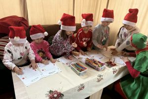 Dzieci piszą list do Mikołajem z Elfem