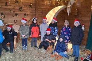 Uczniowie pozują od zdjęcia na tle scenografii świątecznej