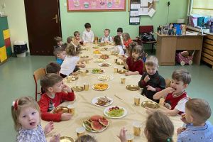 Dzieci siedzą przy wigilijnymm stole.