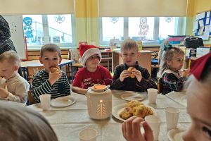 Przedszkolaki podczas wspólnej wigilii przy stole.