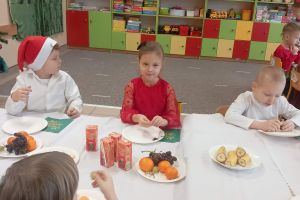 Dzieci częstują się poczęstunkiem ze stołu.