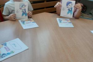 Przedszkolaki trzymają kolorowanki.