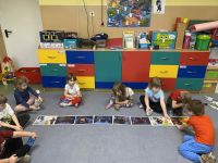 Dzecio uczestniczą w zajęciach na dywanie.