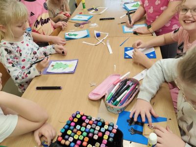 Dzieci ozdabiają pocztówki świąteczne.