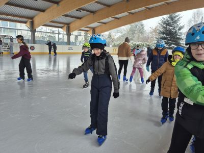 Uczniowie jeżdżą na łyżwach.