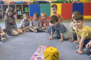 Przedszkolaki rzucają kostką.