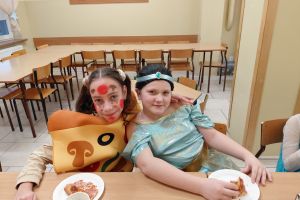 Uczniowie podczas poczęstunku na zabawie karnawałowej.