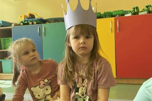 Dziewczynka siedzi z koroną.