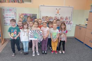 Dzieci trzymają wykonaną prace plastyczną.