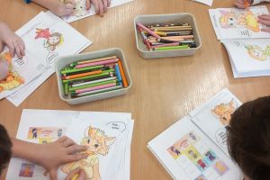 Przedszkolaki kolorują kartę zadań.