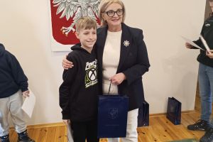 Uczeń klasy czwartej podczas wręczania dyplomu z Wójt Gminy Borowie.