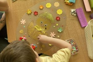 Dzieci ozdabiają pisankę.