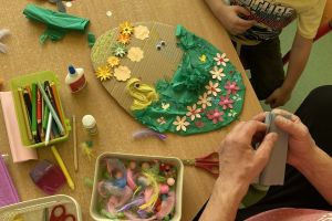 Dzieci na warsztatach tworzą pisanki.